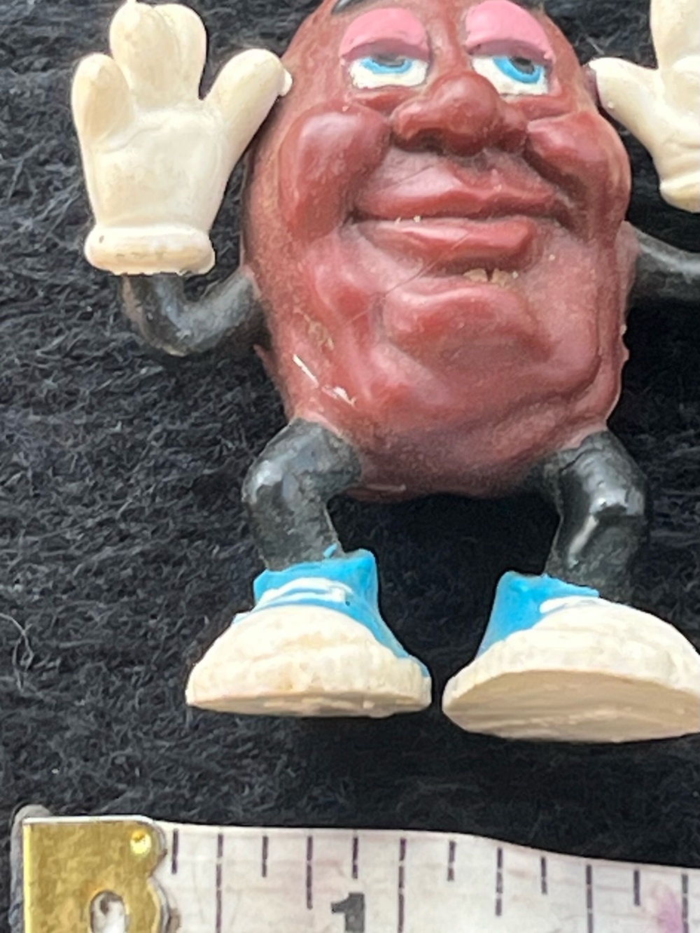 vintage 1987 California Raisins PVC figurine with raised hands and blue shoes.